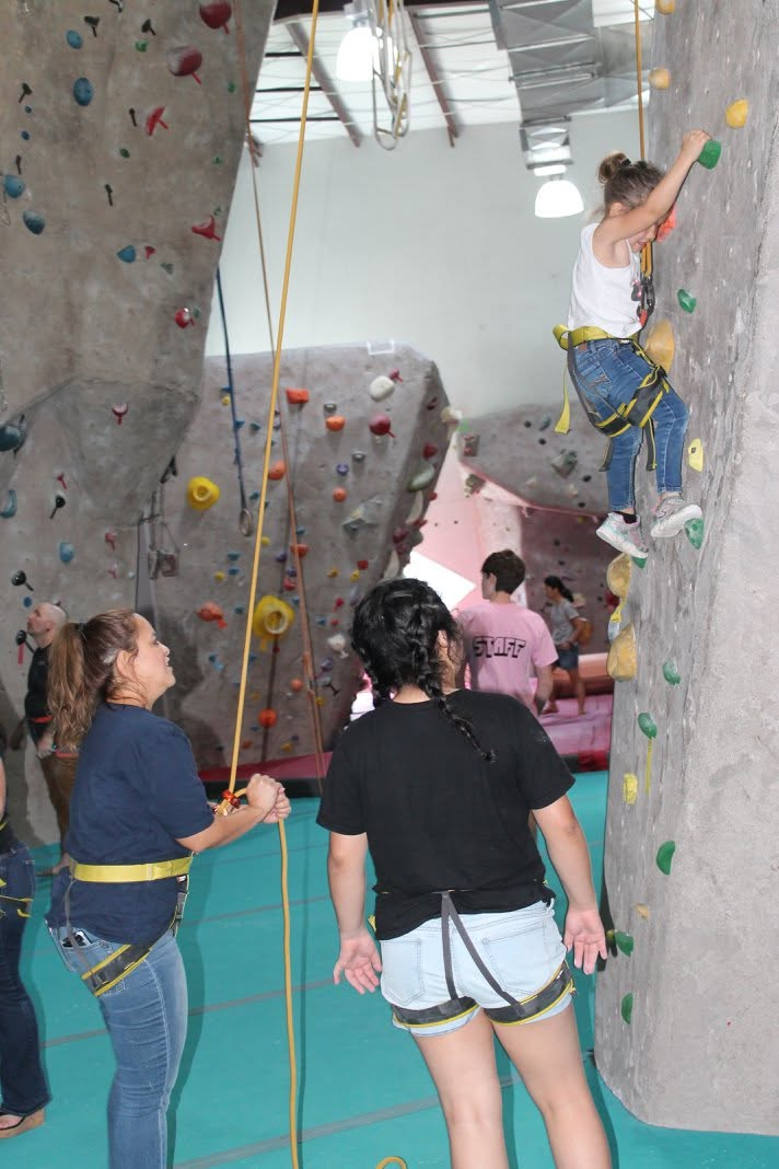 Children and adults participate in an indoor climbing activity